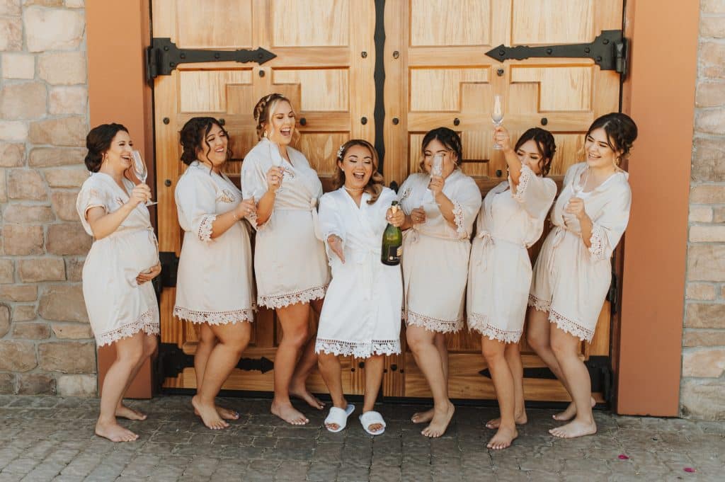 Bridesmaids and a bride popping Champagne 